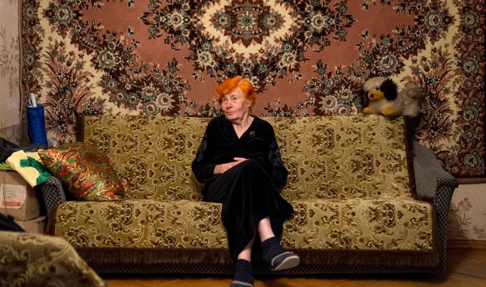Домашняя тетушка. Советский ковер на стене. Старая комната диван с ковром. Советский диван на фоне ковра. Пожилая женщина в квартире.