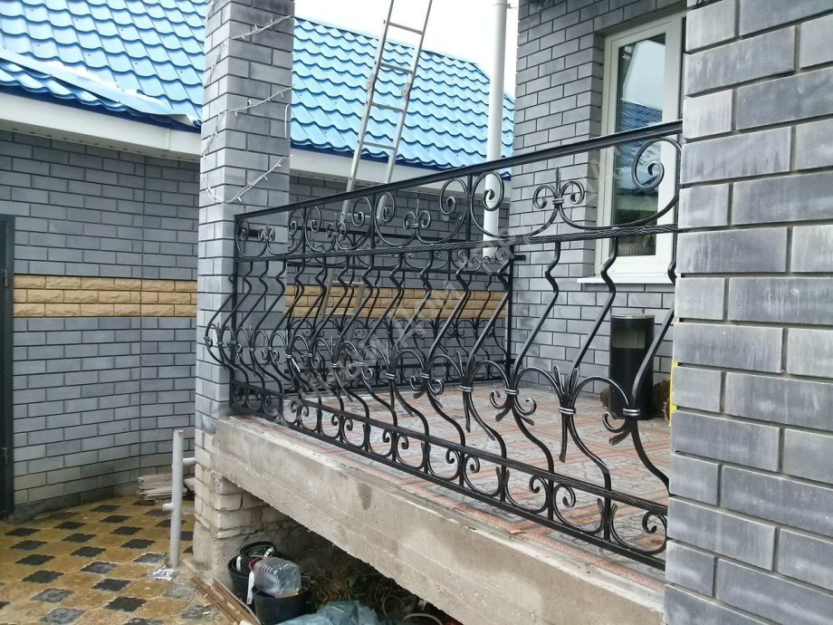 Кованые перила на веранде между столбами